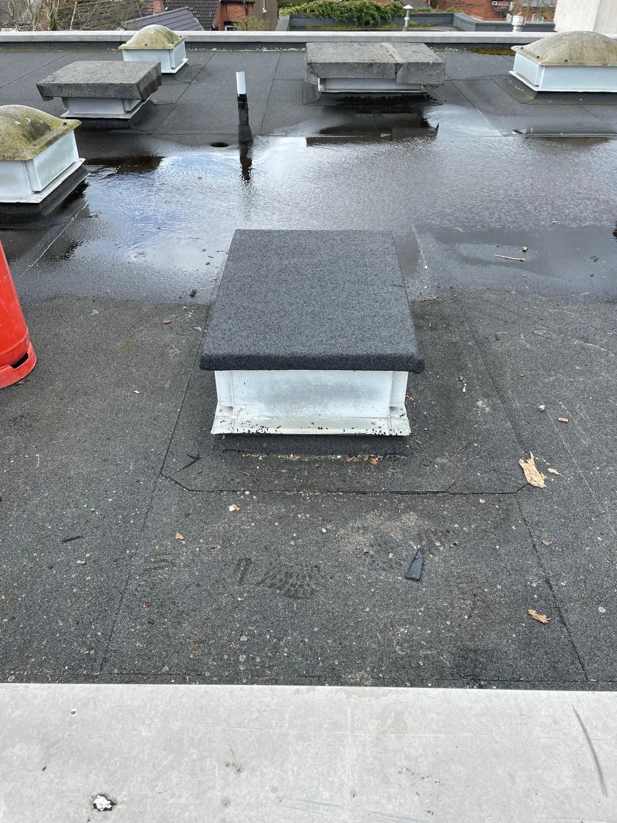 Flat roof with a new covering and roof lights set into it