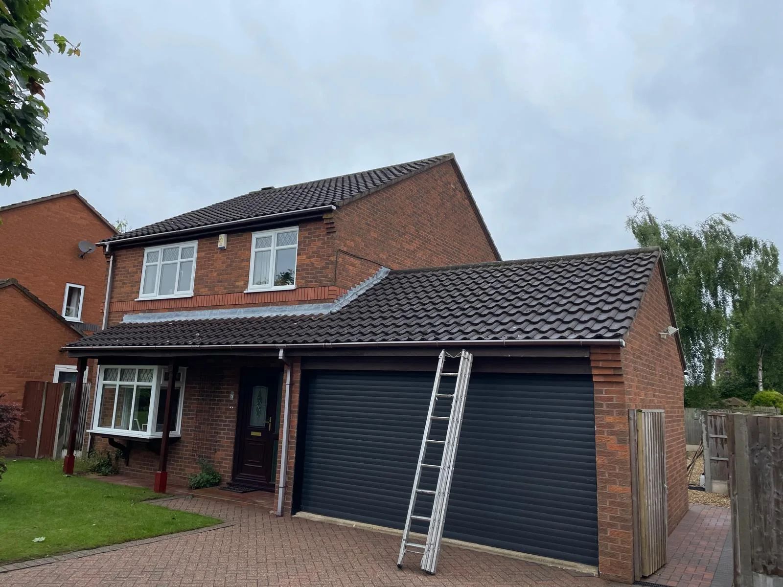 Detached house with a newly laid dark grey tiled roof