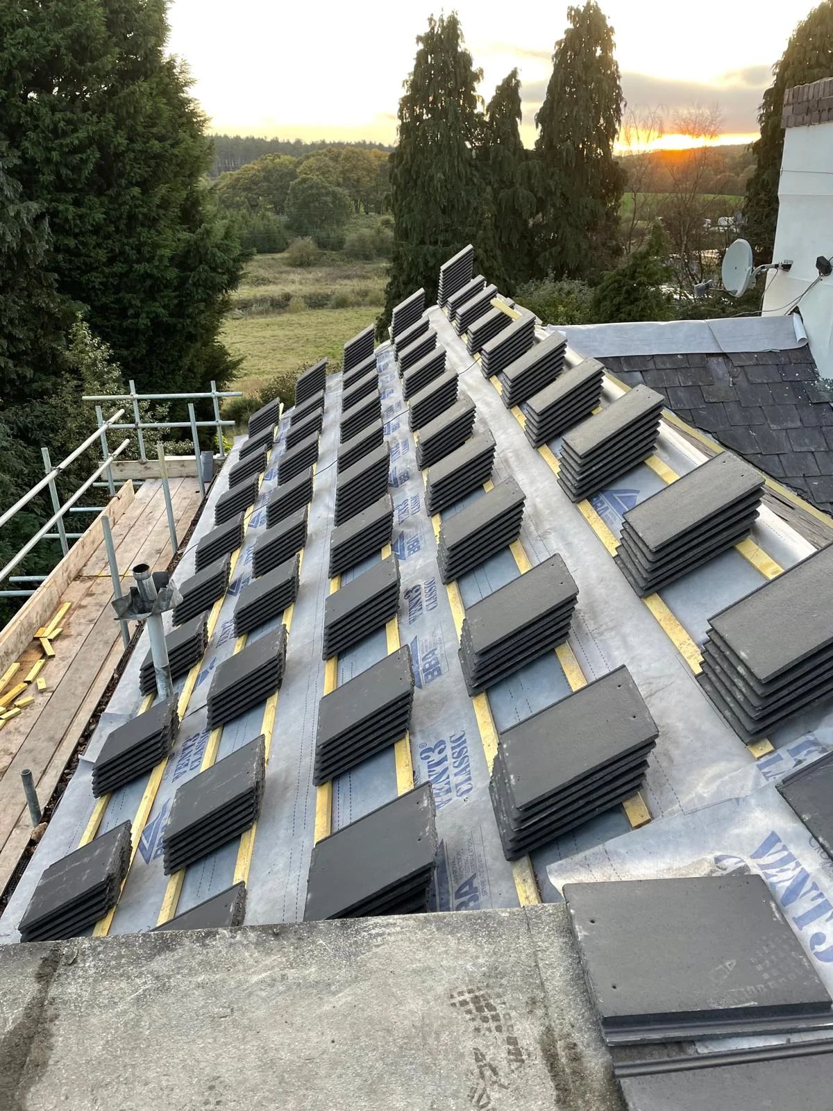 New roof tiles loaded out on fresh battens and membrane during a re-roof