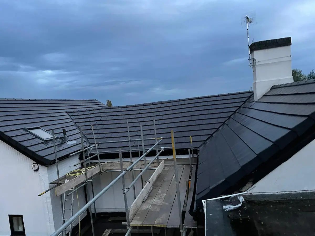 Scaffolding along the eaves of a slate roof during roof work