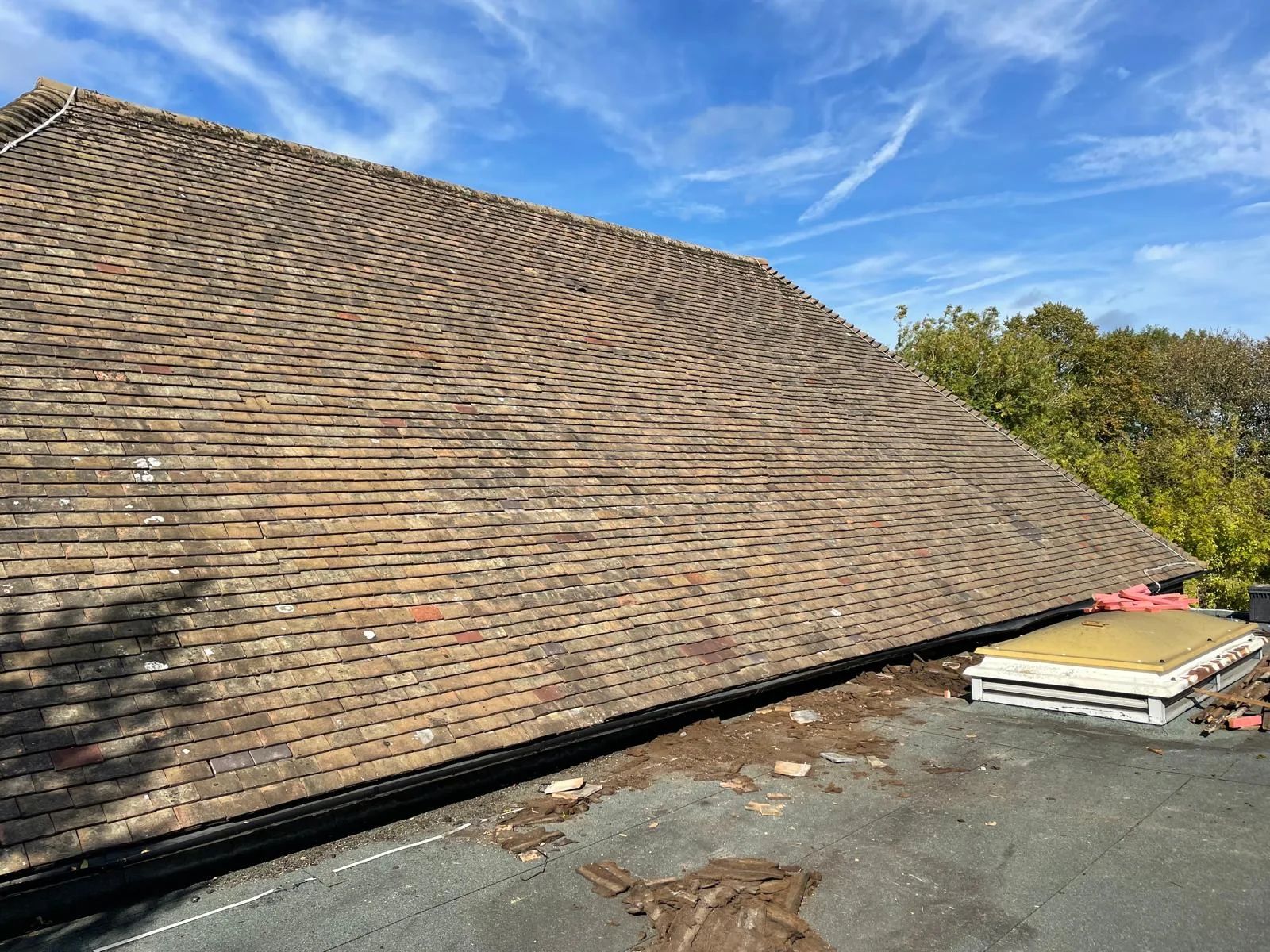 Tiled roof slope running down to a flat roof with a roof light